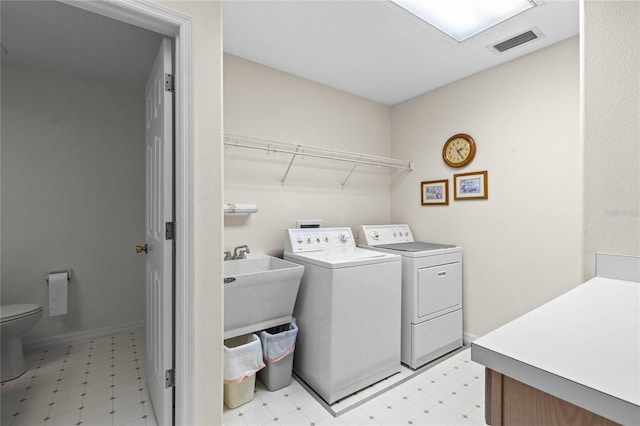 clothes washing area featuring washing machine and dryer and sink