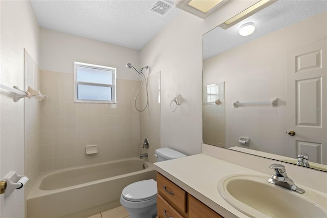 full bathroom featuring toilet, tile patterned flooring, tiled shower / bath, vanity, and a textured ceiling