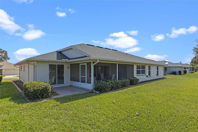 back of house featuring a yard and a sunroom