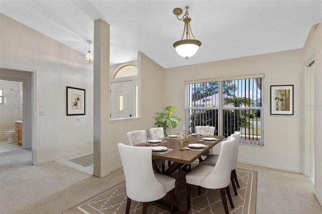 dining room featuring lofted ceiling and light colored carpet