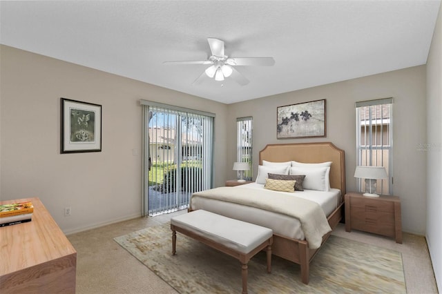 bedroom with multiple windows, access to exterior, light colored carpet, and ceiling fan