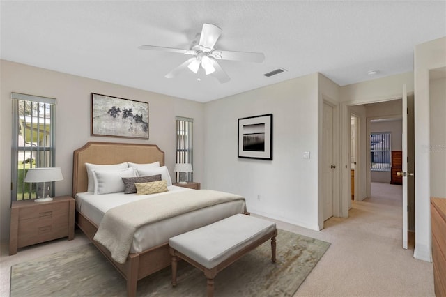 bedroom with ceiling fan and light colored carpet