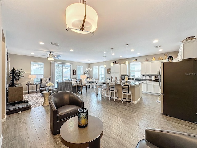 living room with light hardwood / wood-style floors and ceiling fan