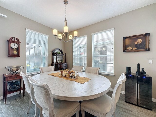 dining space with light hardwood / wood-style flooring and a notable chandelier