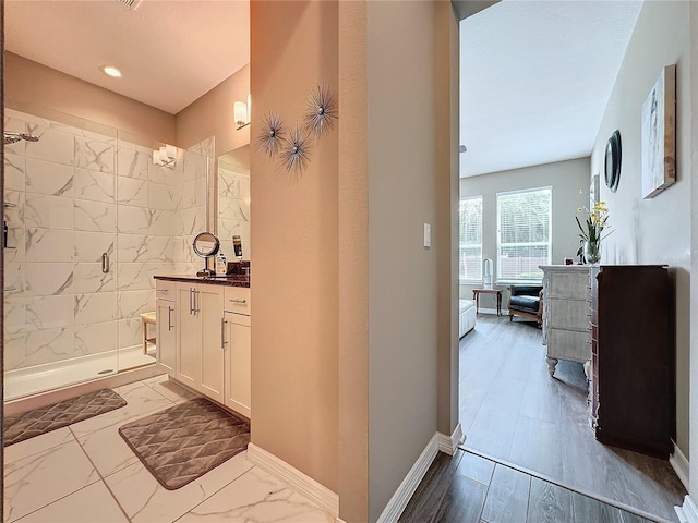 bathroom featuring vanity, hardwood / wood-style flooring, and a shower