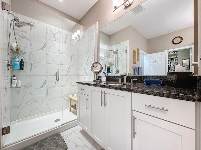 bathroom with a shower with door and vanity