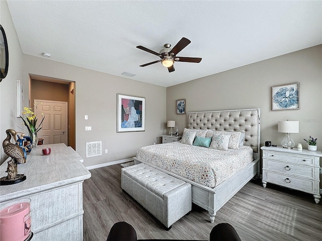 bedroom featuring ceiling fan, dark wood-type flooring, and a textured ceiling