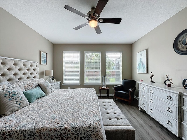 bedroom featuring ceiling fan, dark wood-type flooring, and a textured ceiling