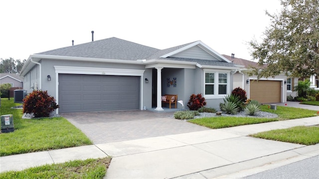 single story home with cooling unit, a front yard, and a garage