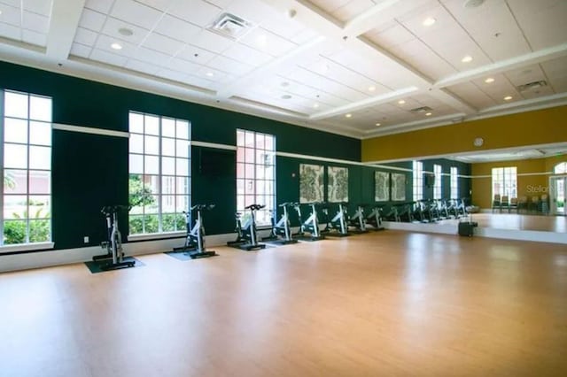 workout area featuring hardwood / wood-style floors, coffered ceiling, and a high ceiling