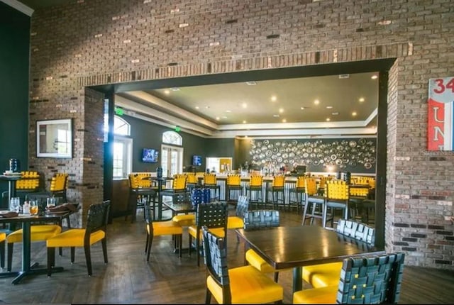 dining space featuring brick wall and a raised ceiling