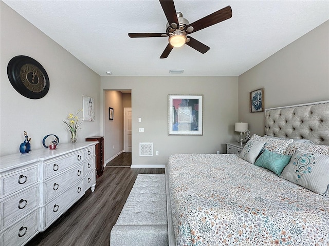 bedroom with ceiling fan, a textured ceiling, and dark hardwood / wood-style flooring