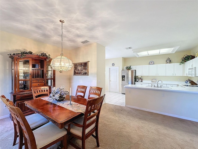 carpeted dining space with sink and an inviting chandelier