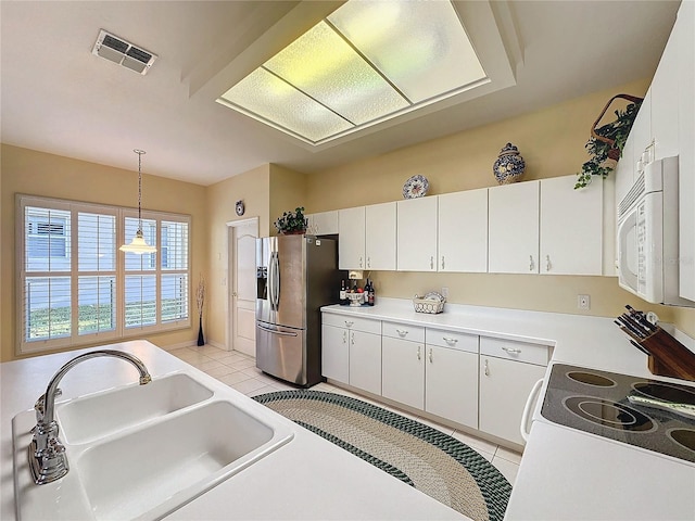 kitchen featuring white cabinetry, sink, pendant lighting, and stainless steel refrigerator with ice dispenser