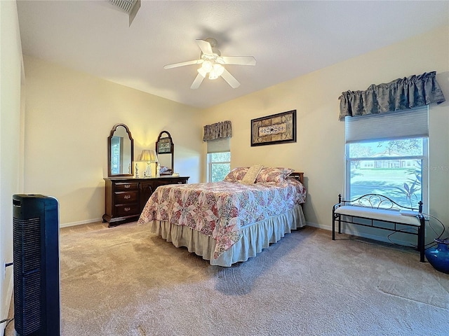 bedroom featuring heating unit, light colored carpet, and ceiling fan