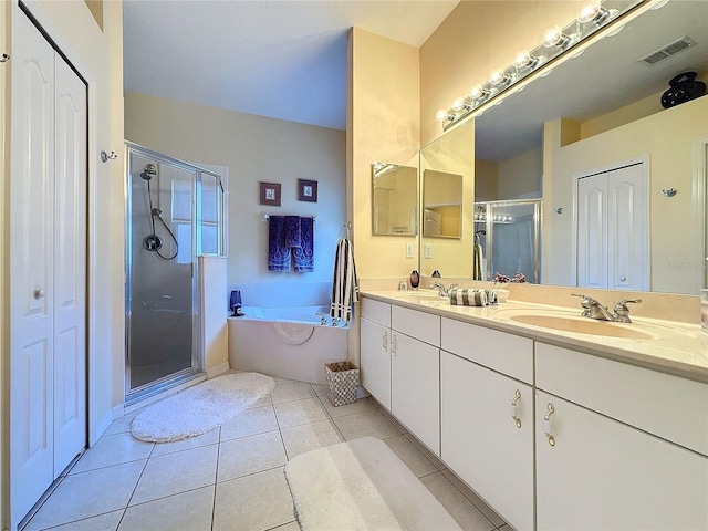 bathroom with tile patterned floors, vanity, and shower with separate bathtub