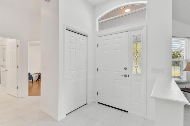 entrance foyer featuring vaulted ceiling and light tile patterned flooring