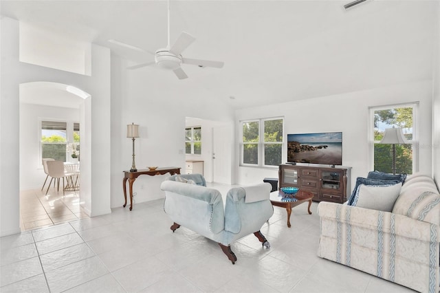 tiled living room with a high ceiling, a healthy amount of sunlight, and ceiling fan