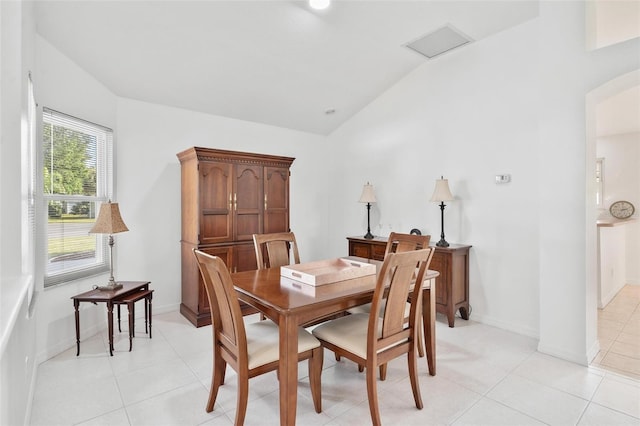 dining room with light tile patterned flooring and vaulted ceiling