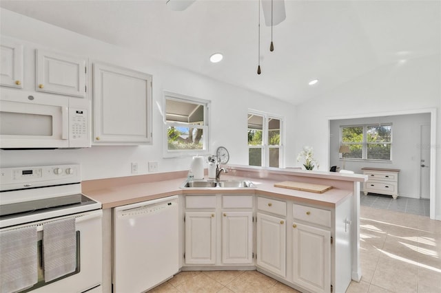 kitchen featuring white appliances, white cabinetry, and vaulted ceiling