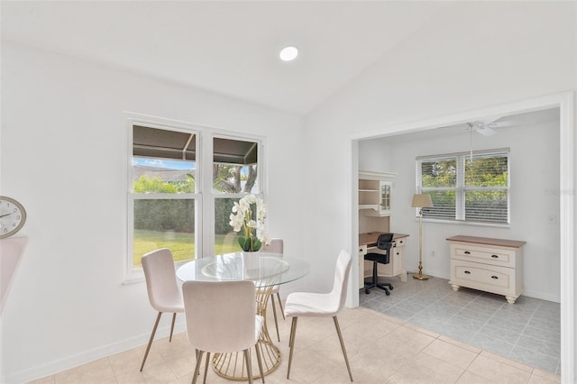 tiled dining space with ceiling fan and lofted ceiling