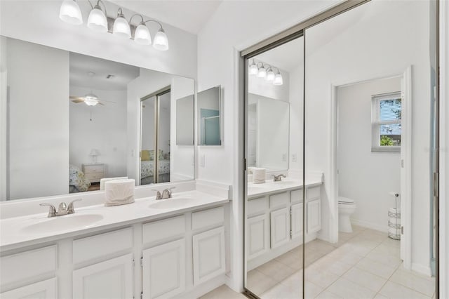 bathroom featuring vanity, toilet, vaulted ceiling, and tile patterned flooring