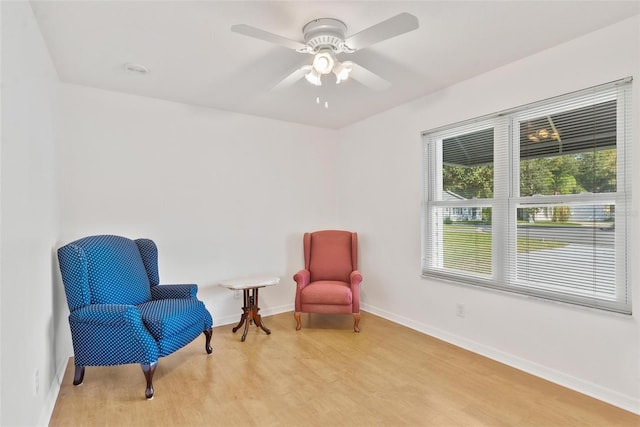 sitting room with ceiling fan and light wood-type flooring