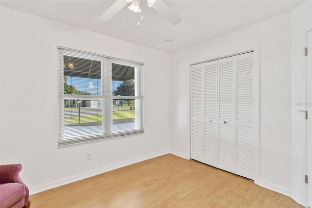 unfurnished bedroom with a closet, light wood-type flooring, and ceiling fan