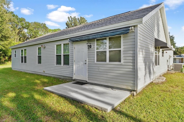 back of house with a yard and central AC unit