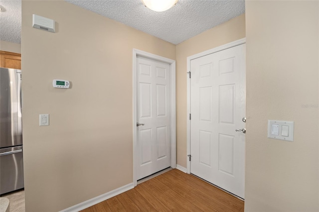 foyer entrance with a textured ceiling and light wood-type flooring