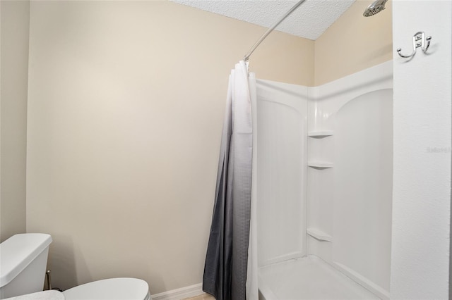 bathroom featuring toilet, a textured ceiling, and a shower with shower curtain