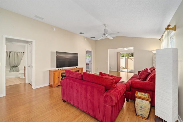 living room with vaulted ceiling, a textured ceiling, light wood-type flooring, and ceiling fan