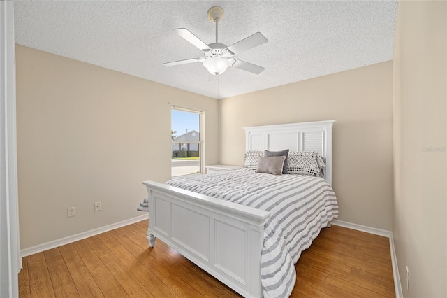 bedroom with light hardwood / wood-style floors, a textured ceiling, and ceiling fan