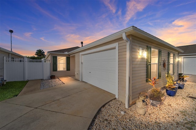 547 Richburg St, The Villages, FL 32162 - property exterior at dusk featuring concrete driveway, a garage, and fence