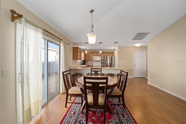 dining area with sink and light hardwood / wood-style flooring