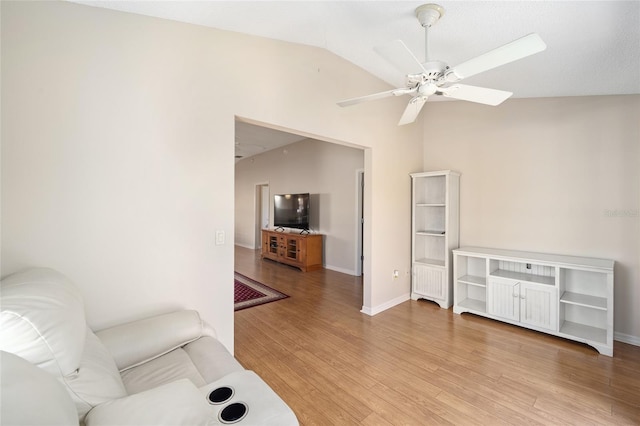 living area with ceiling fan, lofted ceiling, and light hardwood / wood-style floors