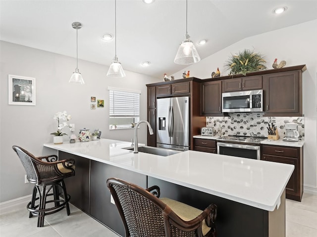 kitchen featuring stainless steel appliances, vaulted ceiling, kitchen peninsula, and hanging light fixtures