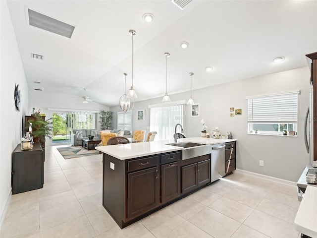 kitchen featuring lofted ceiling, light tile patterned floors, dishwasher, pendant lighting, and sink