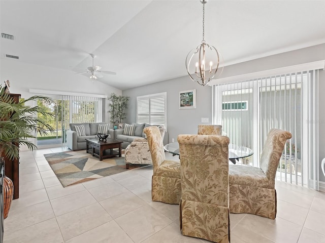 tiled dining space with ceiling fan with notable chandelier and vaulted ceiling