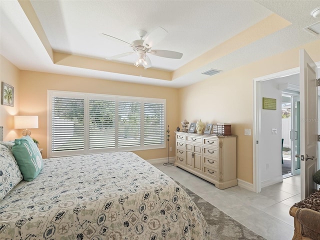 bedroom with a tray ceiling and ceiling fan