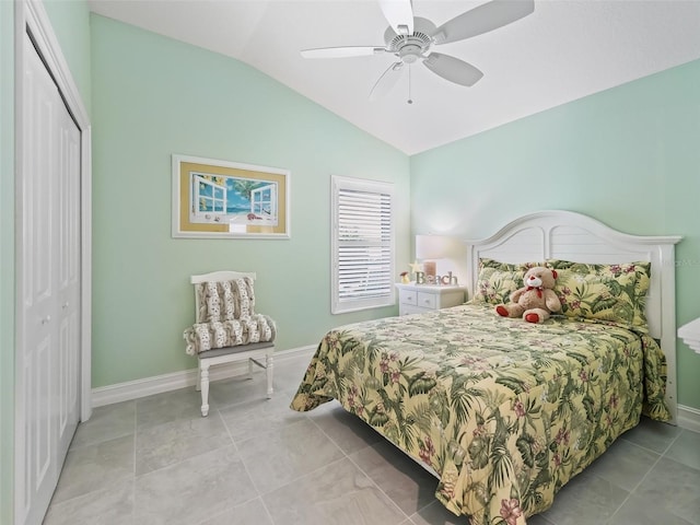 tiled bedroom with a closet, lofted ceiling, and ceiling fan