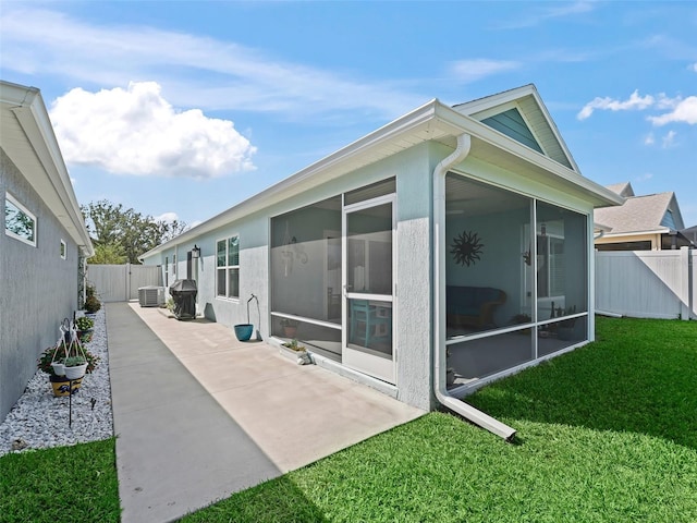 back of house with central AC unit, a patio area, a lawn, and a sunroom