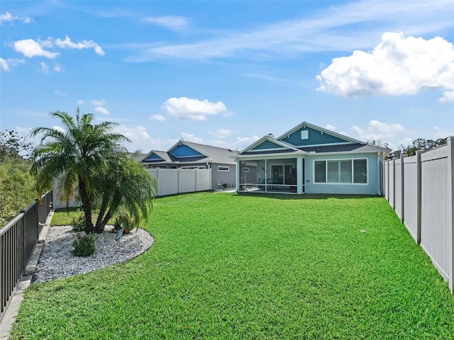 rear view of property featuring a yard and a sunroom