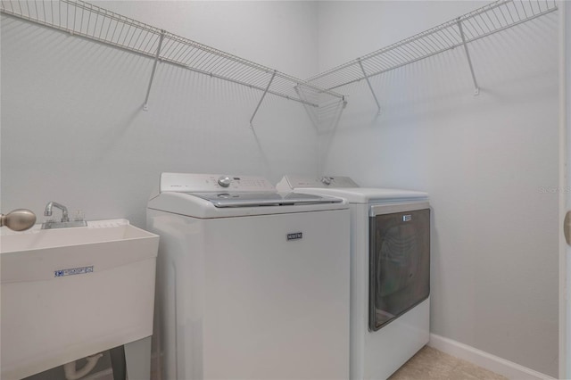 clothes washing area featuring sink and washing machine and clothes dryer