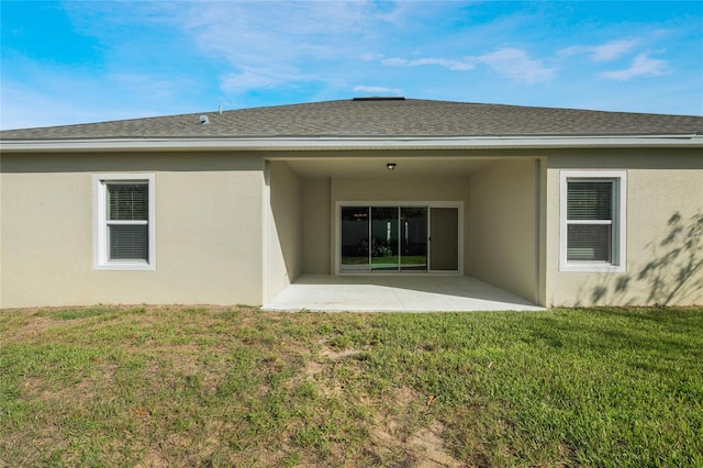 back of property with a yard and a patio