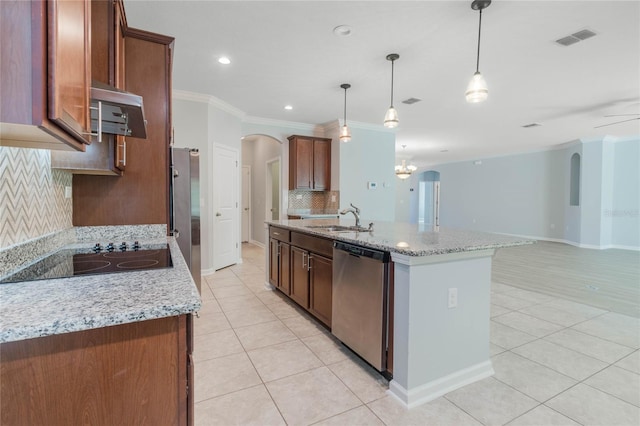 kitchen with an island with sink, backsplash, sink, decorative light fixtures, and appliances with stainless steel finishes