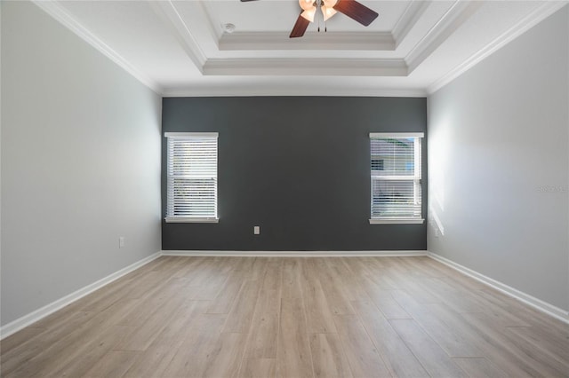 spare room featuring crown molding, a tray ceiling, light hardwood / wood-style flooring, and ceiling fan