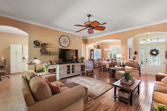 living room with crown molding, ceiling fan with notable chandelier, and light wood-type flooring