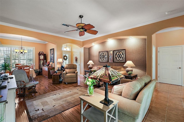 living room featuring crown molding, hardwood / wood-style flooring, and ceiling fan with notable chandelier