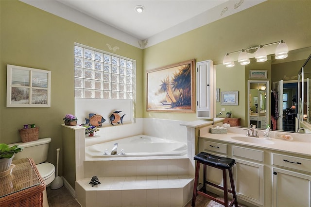 bathroom featuring vanity, toilet, a relaxing tiled tub, and tile patterned flooring